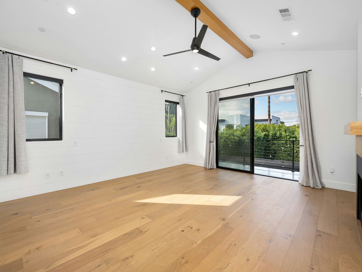 Freshly finished empty room with bare floors and clean glass doors